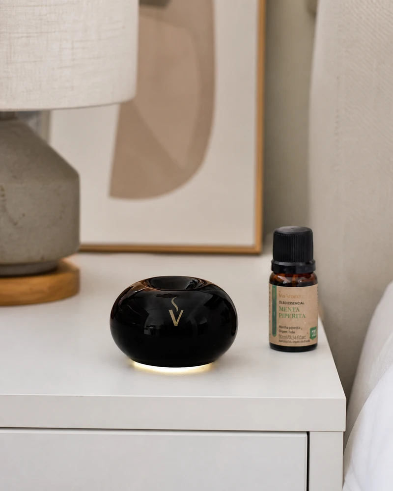 Aromatizador elétrico USB preto Via Aroma ao lado de notebook